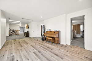 Living area with light wood-type flooring, baseboards, and recessed lighting