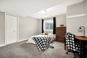 Carpeted bedroom with a closet and baseboards