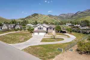 View of front of house with concrete driveway, a garage, and a mountain view
