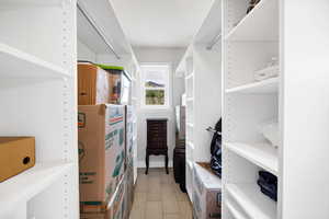 Walk in closet with light wood-style flooring
