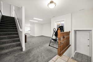 Stairway featuring baseboards, carpet floors, and a textured ceiling