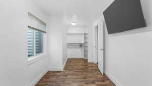 Corridor featuring dark wood-type flooring and baseboards