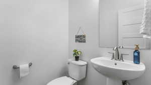 Half bath featuring a sink and toilet