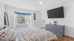 Bedroom with wood finished floors and baseboards