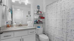 Full bath featuring toilet, vanity, and a shower with shower curtain