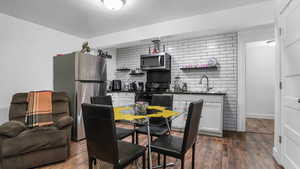 Dining space featuring dark wood-type flooring and bar
