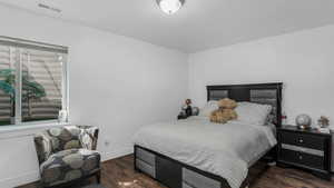 Bedroom featuring wood finished floors and baseboards