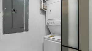 Washroom featuring stacked washer / dryer and electric panel