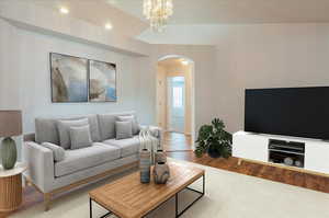 Living room featuring arched walkways, recessed lighting, baseboards, and a chandelier