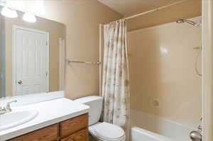 Bathroom featuring vanity, toilet, and shower / bath combination with curtain