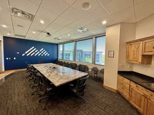 Dining room featuring baseboards, dark colored carpet, recessed lighting, and a drop ceiling