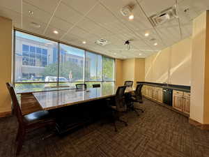 Office space with dark carpet, baseboards, a sink, and recessed lighting
