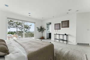 Bedroom with light colored carpet, access to outside, recessed lighting, and baseboards