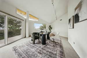 Carpeted dining area featuring vaulted ceiling
