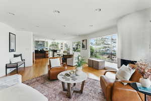 Living area with light wood finished floors and recessed lighting