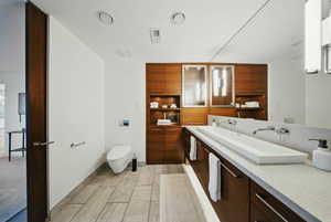 Bathroom featuring toilet, vanity, and baseboards
