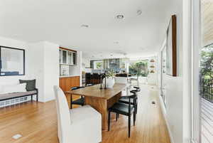 Dining area with light wood-style flooring, healthy amount of natural light, recessed lighting, and baseboards