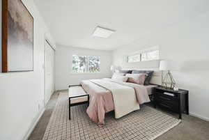 Bedroom with light colored carpet and baseboards