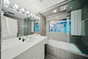 Full bath featuring tiled shower / bath, tile walls, vanity, and tile patterned floors