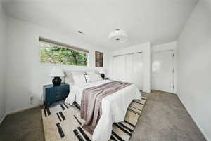 Carpeted bedroom with a closet and baseboards