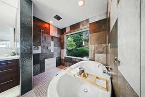 Full bathroom featuring tile walls, a bathtub, tiled shower, healthy amount of natural light, and recessed lighting