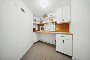 Kitchen featuring open shelves, light tile patterned flooring, white cabinets, baseboards, and butcher block counters