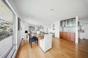 Dining space with light wood-type flooring, bar, and recessed lighting