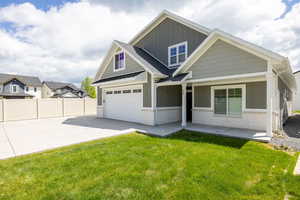 View of front facade featuring board and batten siding, driveway, a garage, and stone siding