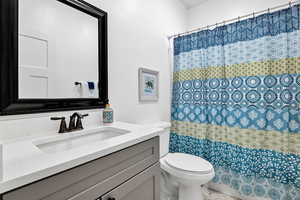 Full bath featuring toilet, vanity, and a shower with curtain