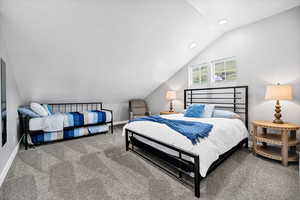 Carpeted bedroom with vaulted ceiling, recessed lighting, and baseboards