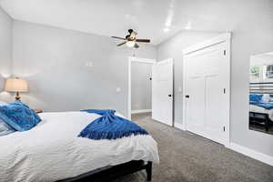 Bedroom with carpet floors, baseboards, a ceiling fan, a closet, and vaulted ceiling