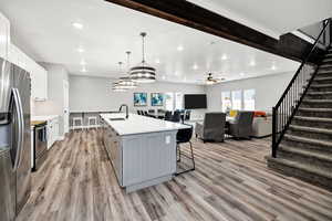 Kitchen with a sink, appliances with stainless steel finishes, light countertops, light wood-style flooring, and recessed lighting