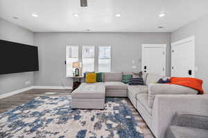 Living area featuring wood finished floors, recessed lighting, and baseboards