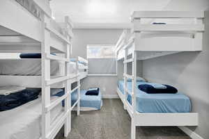 Bedroom with carpet floors, baseboards, and a textured ceiling