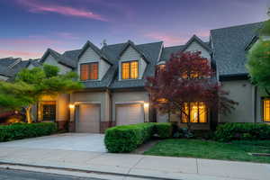 View of front of property featuring a garage, concrete driveway, roof with shingles, and a front lawn