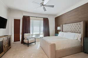 Bedroom featuring crown molding, light carpet, and a ceiling fan