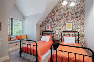 Carpeted bedroom featuring vaulted ceiling and baseboards