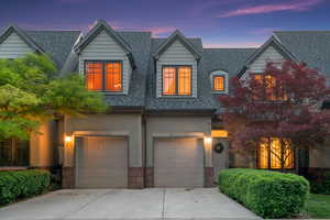 View of front facade with driveway, a garage, and a shingled roof