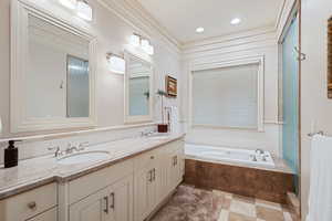 Full bathroom featuring double vanity, a garden tub, and recessed lighting