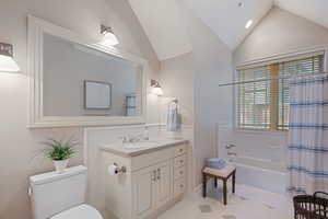 Full bath with vaulted ceiling, toilet, vanity, shower / tub combo with curtain, and tile patterned flooring