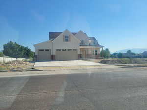 View of front of home with board and batten siding, a mountain view, concrete driveway, an attached garage, and a porch