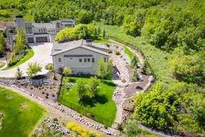 Aerial view of property and surrounding area featuring a forest