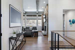 Corridor with hardwood / wood-style floors, baseboards, recessed lighting, and an upstairs landing