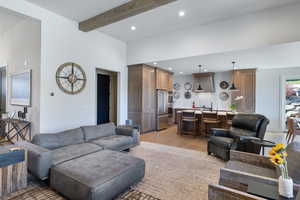 Living area featuring light wood-type flooring, recessed lighting, and beamed ceiling