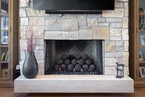 Detailed view of a fireplace and wood finished floors