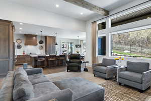 Living area featuring light wood finished floors, recessed lighting, and beam ceiling