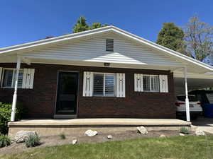 View of front of home featuring brick siding and an attached carport
