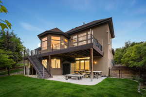 Back of house featuring stucco siding, a patio area, stairway, and a deck