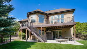 Back of house with a patio area, roof with shingles, a deck, and stairs