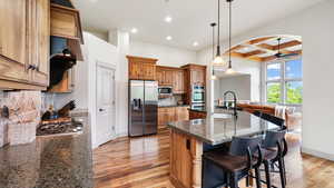 Kitchen with appliances with stainless steel finishes, coffered ceiling, a sink, light wood-style flooring, and recessed lighting